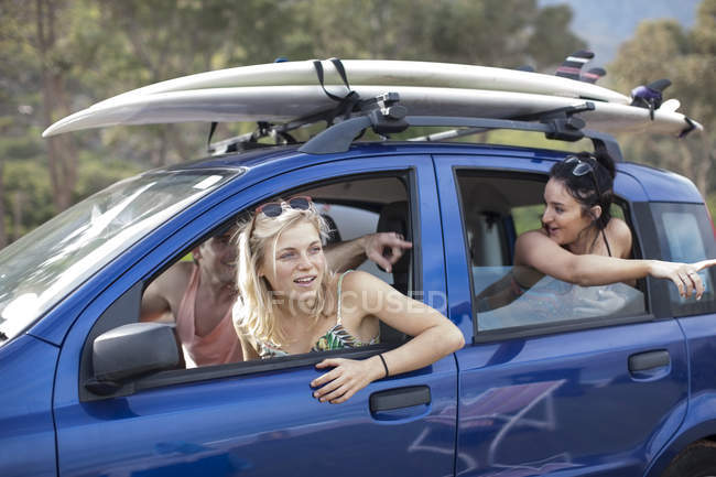 Amici omn un viaggio in auto con tavole da surf sul tetto — Foto stock
