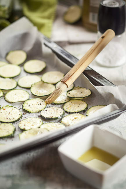 Close up of Slices of courgettes on baking tray — Stock Photo