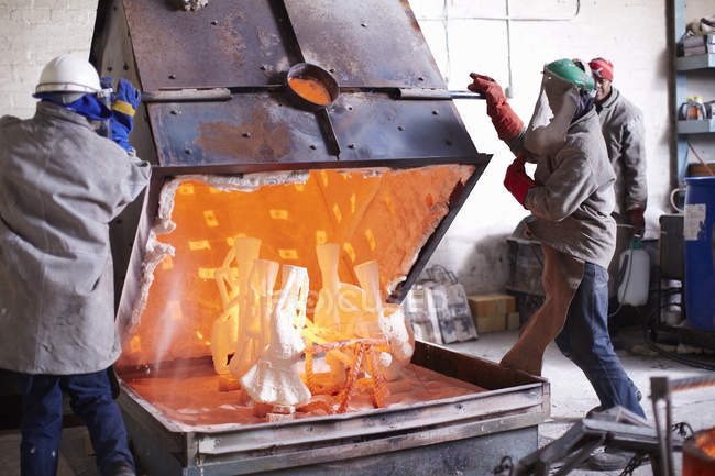 South Africa, Cape Town. Workers opening burnout oven with casting molds — Stock Photo