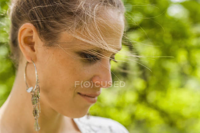Mulher sorridente com brinco ao ar livre — Fotografia de Stock