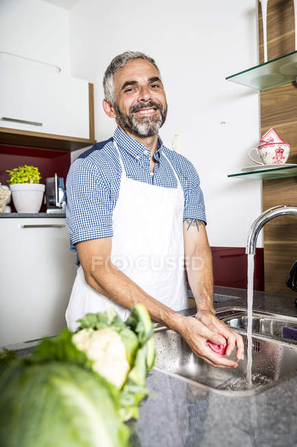 Austria, Hombre en la cocina lavando verduras - foto de stock