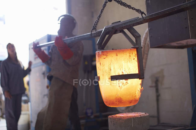 Art foundry workers melting bronze — Stock Photo