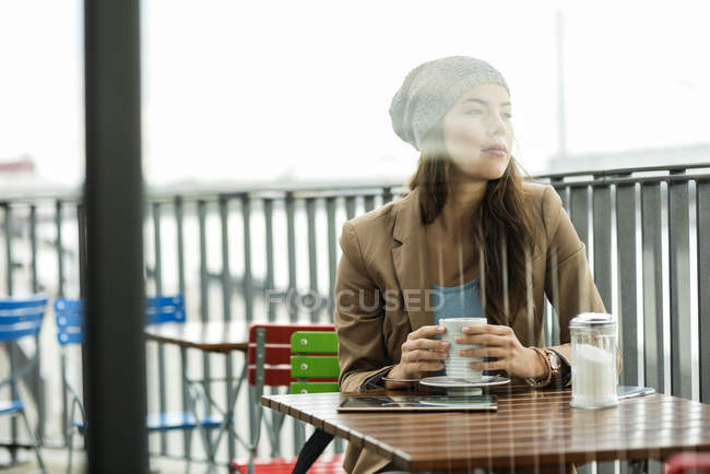 Frau sitzt im Straßencafé — Stockfoto