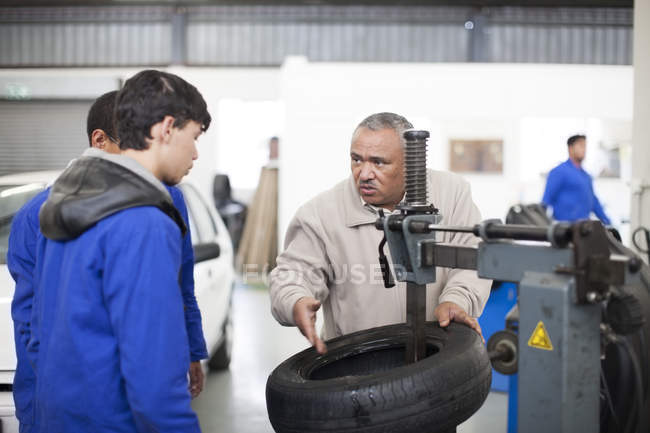 Instructor teaching trainees in repair garage — Stock Photo