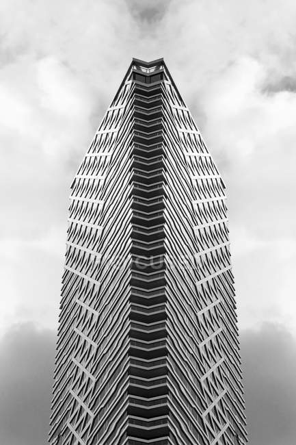 Skyscraper against clouds, black and white shot — Stock Photo