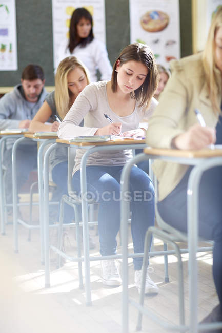 Cropped portrait of students in classroom having an exam — Stock Photo