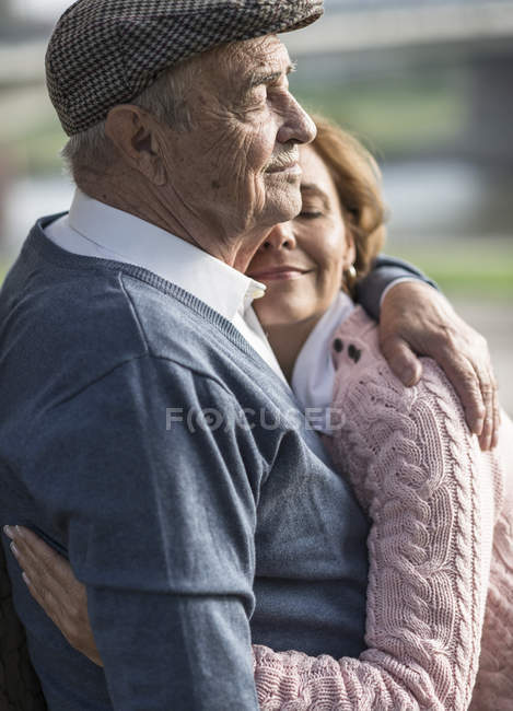 Fille embrassant homme âgé à l'extérieur — Photo de stock