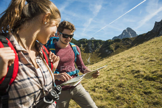 Áustria, Tirol, Tannheimer Tal, jovens caminhantes a olhar para o mapa — Fotografia de Stock