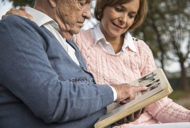 Uomo anziano e figlia guardando album di foto — Foto stock