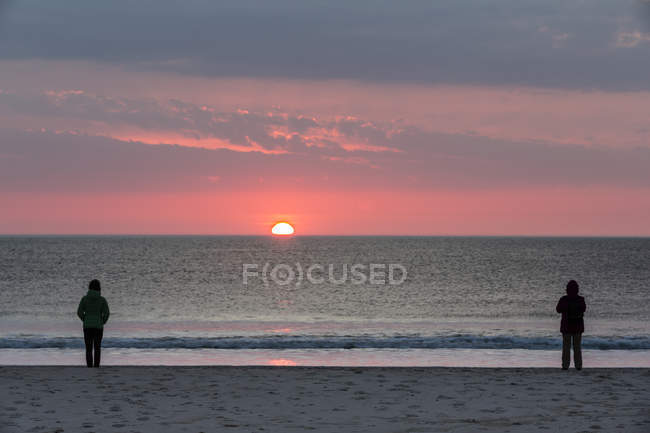 Alemanha, Schleswig-Holstein, Sylt, pôr do sol na praia, duas pessoas silhuetas — Fotografia de Stock
