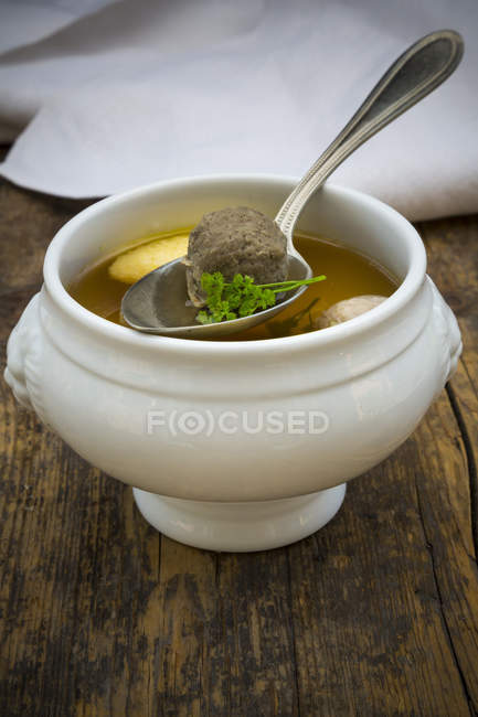 Soup bowl of Swabian soup with dumpling on wood — Stock Photo
