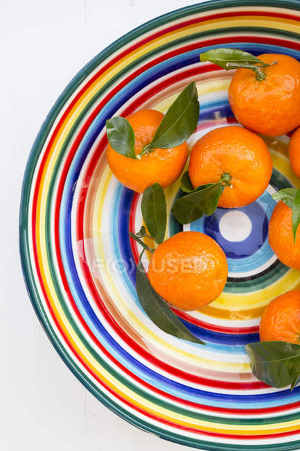 Вид зверху барвисті mandarines з листя в миску — стокове фото