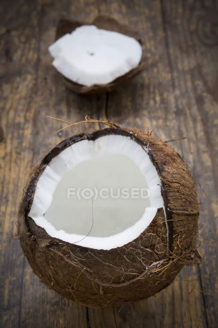 Coco fresco abierto sobre madera oscura - foto de stock