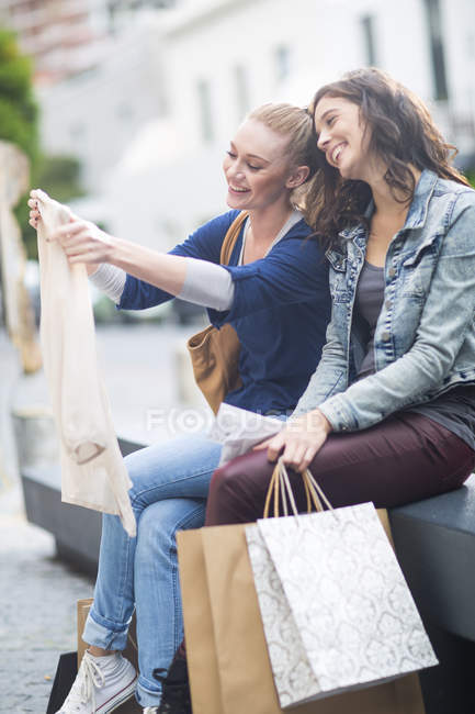 Due amiche che guardano i loro acquisti — Foto stock
