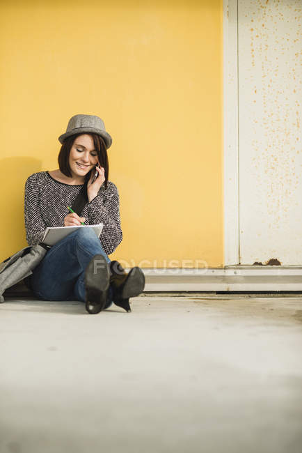 Woman sitting on floor with notebook — Stock Photo
