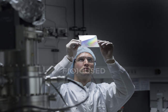 Technicien examinant l'échantillon en salle blanche — Photo de stock