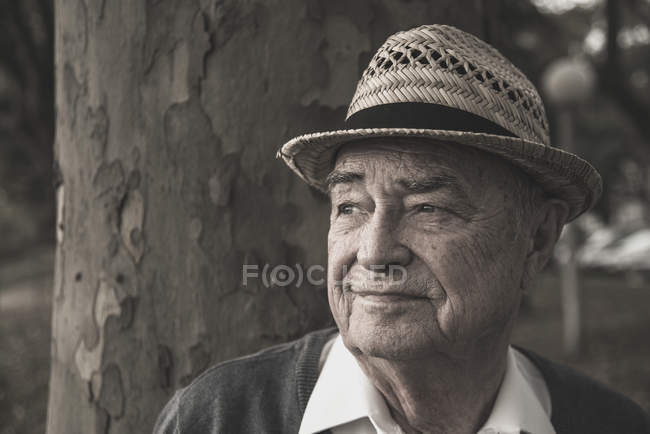 Uomo anziano che indossa cappello di paglia pensando — Foto stock