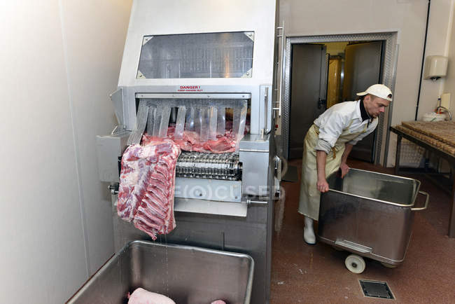 Человек, стоящий у машины для маринования в мясной лавке — стоковое фото