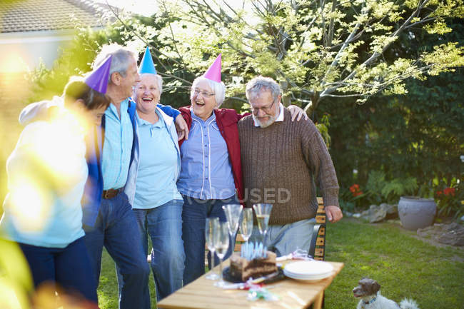 Amici anziani su una festa di compleanno in giardino — Foto stock