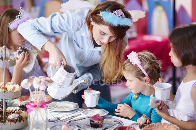 Meninas e adolescente em uma festa de chá em diademas — Fotografia de Stock