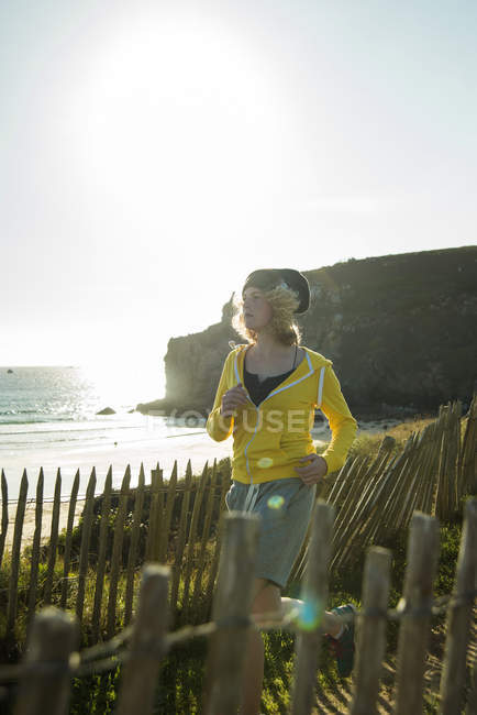 France, Brittany, Camaret-sur-Mer, teenage girl running on coastal path — Stock Photo