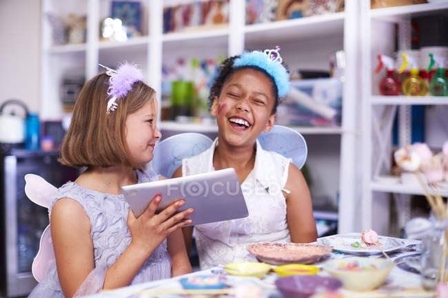 Duas meninas usando tablet digital em uma festa de aniversário — Fotografia de Stock