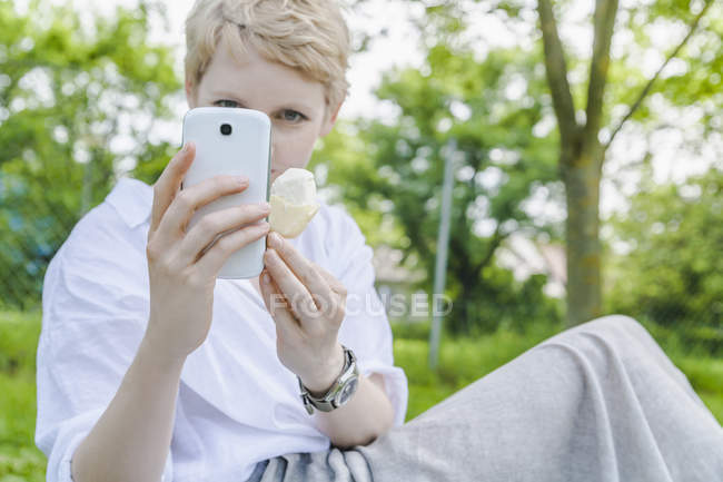 Woman with ice lolly in her hand taking selfie with smartphone — Stock Photo