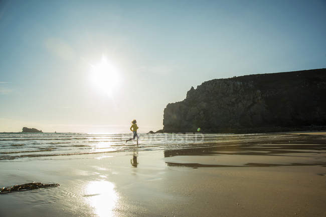 France, Brittany, Camaret-sur-Mer, teenage girl running in the ocean — Stock Photo