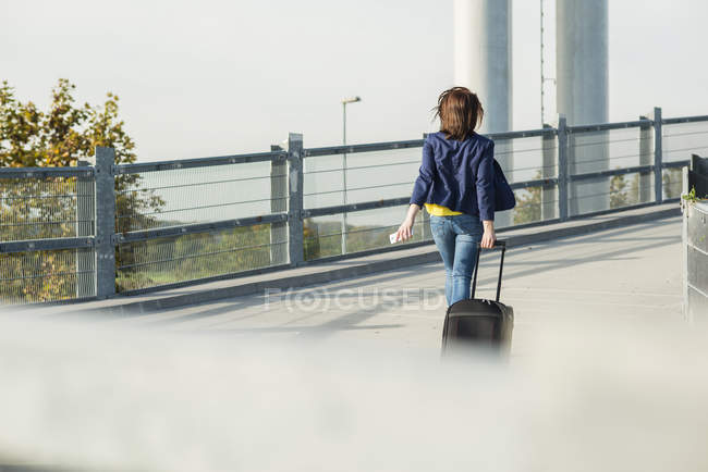 Woman with baggage walking in parking garage — Stock Photo