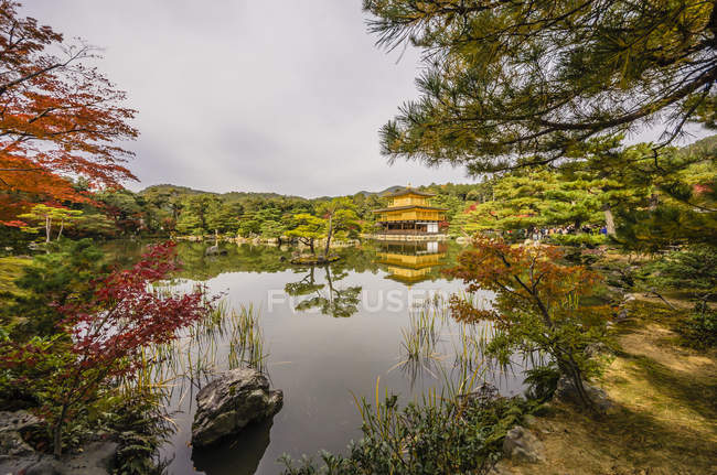 Japón, Kioto, templo budista Kinkaku-ji con parque durante el día - foto de stock