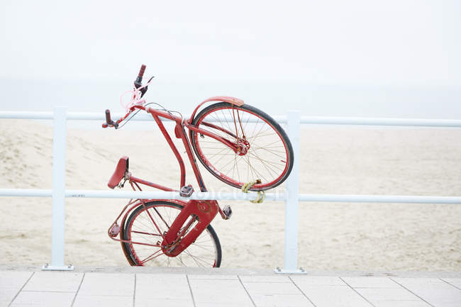 Países Bajos, Scheveningen, rojo roadster holandés fijado en una barandilla cerca de la playa - foto de stock