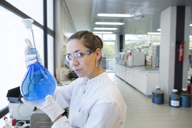 Молодий вчений жінка з лампа скла в хімічної лабораторії — стокове фото