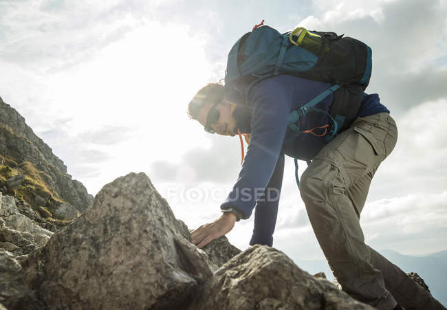 Austria, Tyrol, Tannheimer Tal, young man climbing on rock — Stock Photo