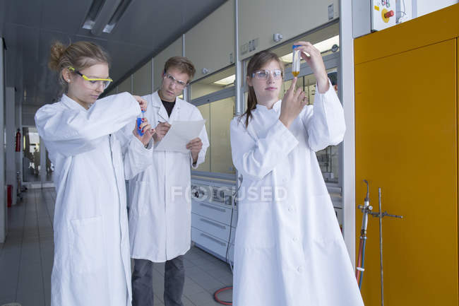 Trois chimistes travaillant dans un laboratoire de chimie font des tests — Photo de stock