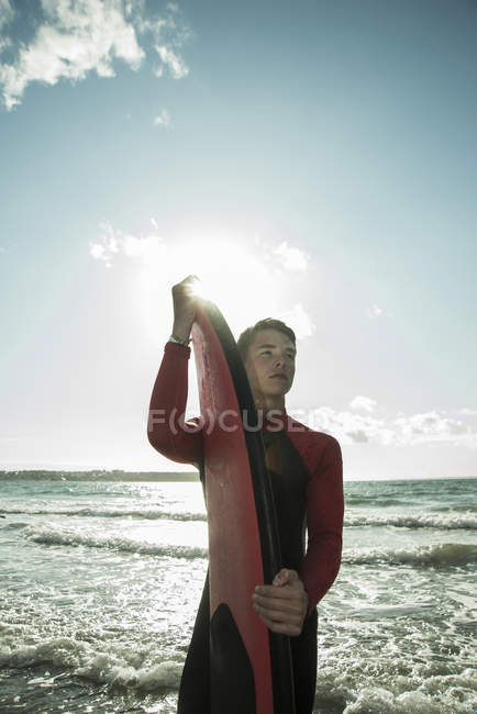 Francia, Bretagna, Camaret-sur-Mer, adolescente con tavola da surf sull'oceano — Foto stock