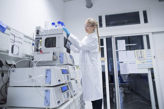 Joven científica trabajando en un laboratorio de investigación de farmacia - foto de stock