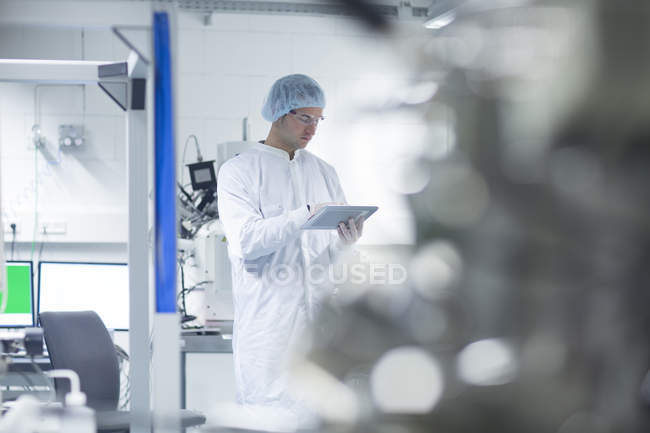 Technicien tenant une tablette numérique en salle blanche — Photo de stock