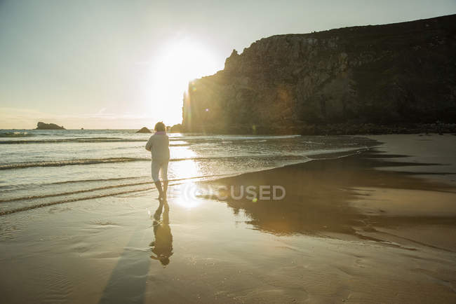 France, Brittany, Camaret-sur-Mer, senior woman standing on the beach — Stock Photo