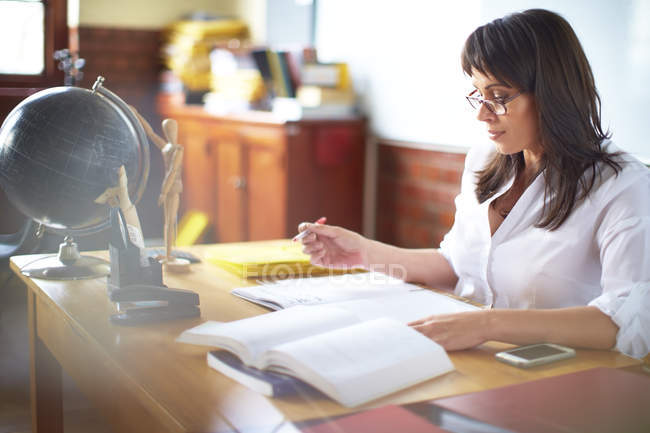 Teacher writing at desk — Stock Photo