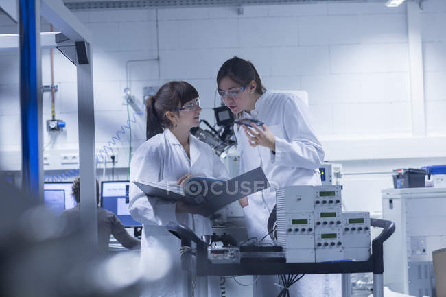 Dos técnicas femeninas trabajando juntas en un laboratorio técnico - foto de stock