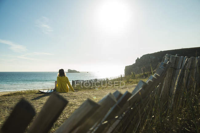 France, Brittany, Camaret-sur-Mer, teenage girl sitting at the coast — Stock Photo