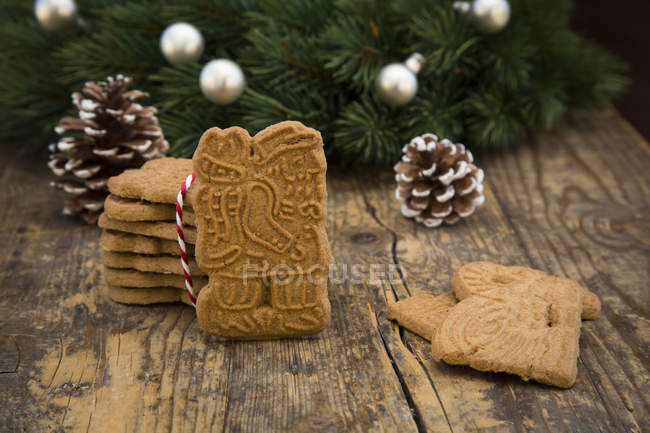 Almond biscuits, fir cones and decorated fir branch on wood — Stock Photo