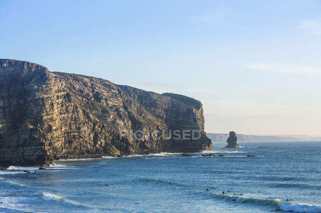 Surfistas por costa atlántica rocosa - foto de stock