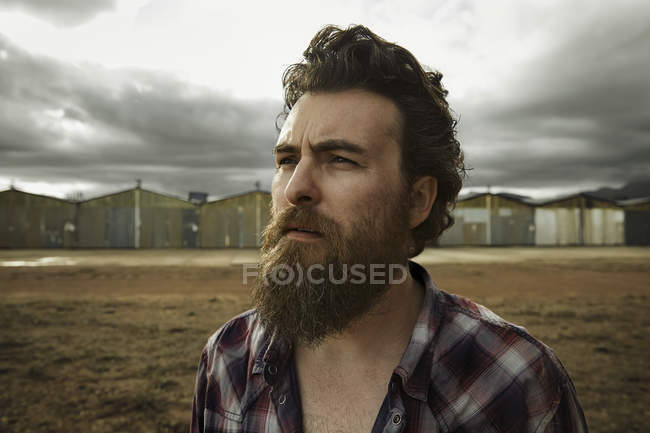 Serious man with full beard in abandoned landscape — Stock Photo
