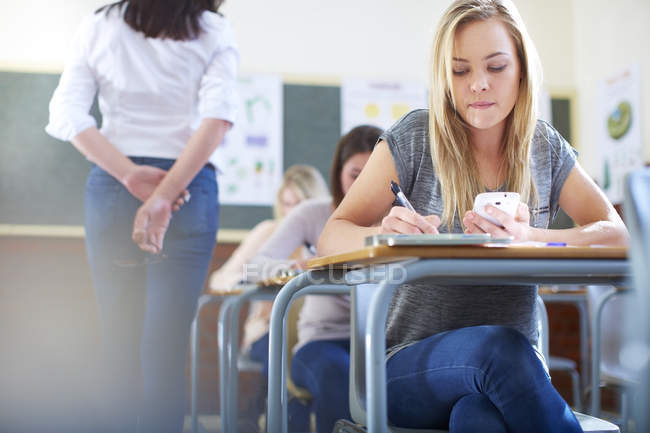 Female student in classroom cheating during an exam — Stock Photo
