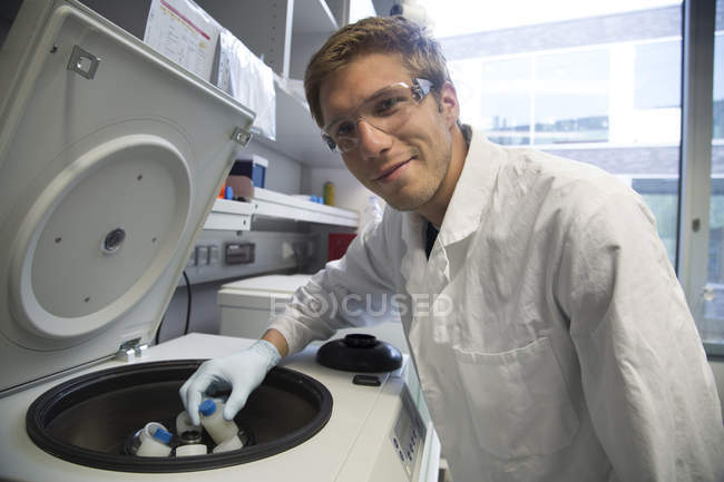 Lächelnder Wissenschaftler, der in einem biologischen Labor arbeitet — Stockfoto