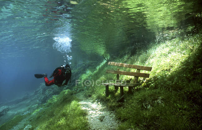 Diver in front of park bench underwater — Stock Photo