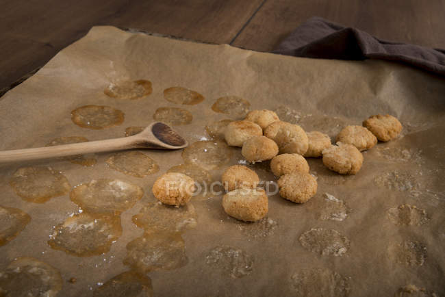 Домашнє печиво амареттіні на пергаменті з дерев'яною ложкою — стокове фото