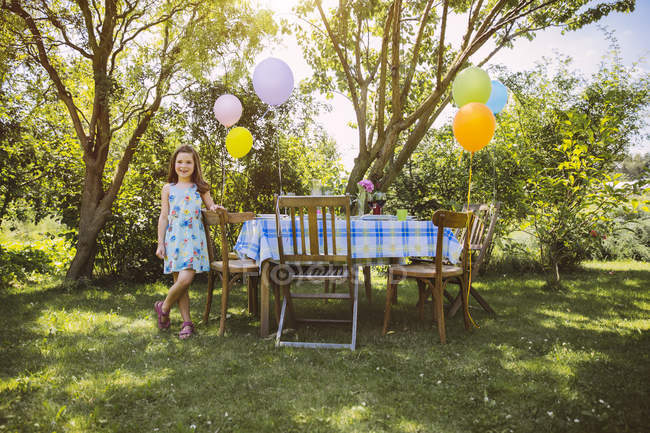 Молодий кавказька дівчинка з повітряними кулями у саду — стокове фото