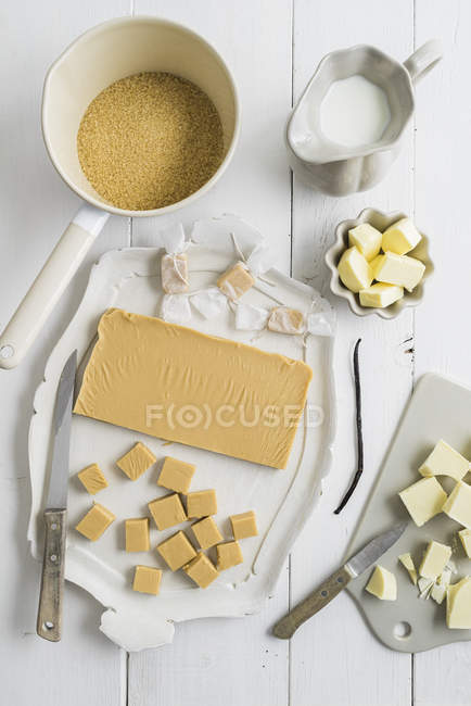 Ingredients for homemade toffees on white wooden table — Stock Photo